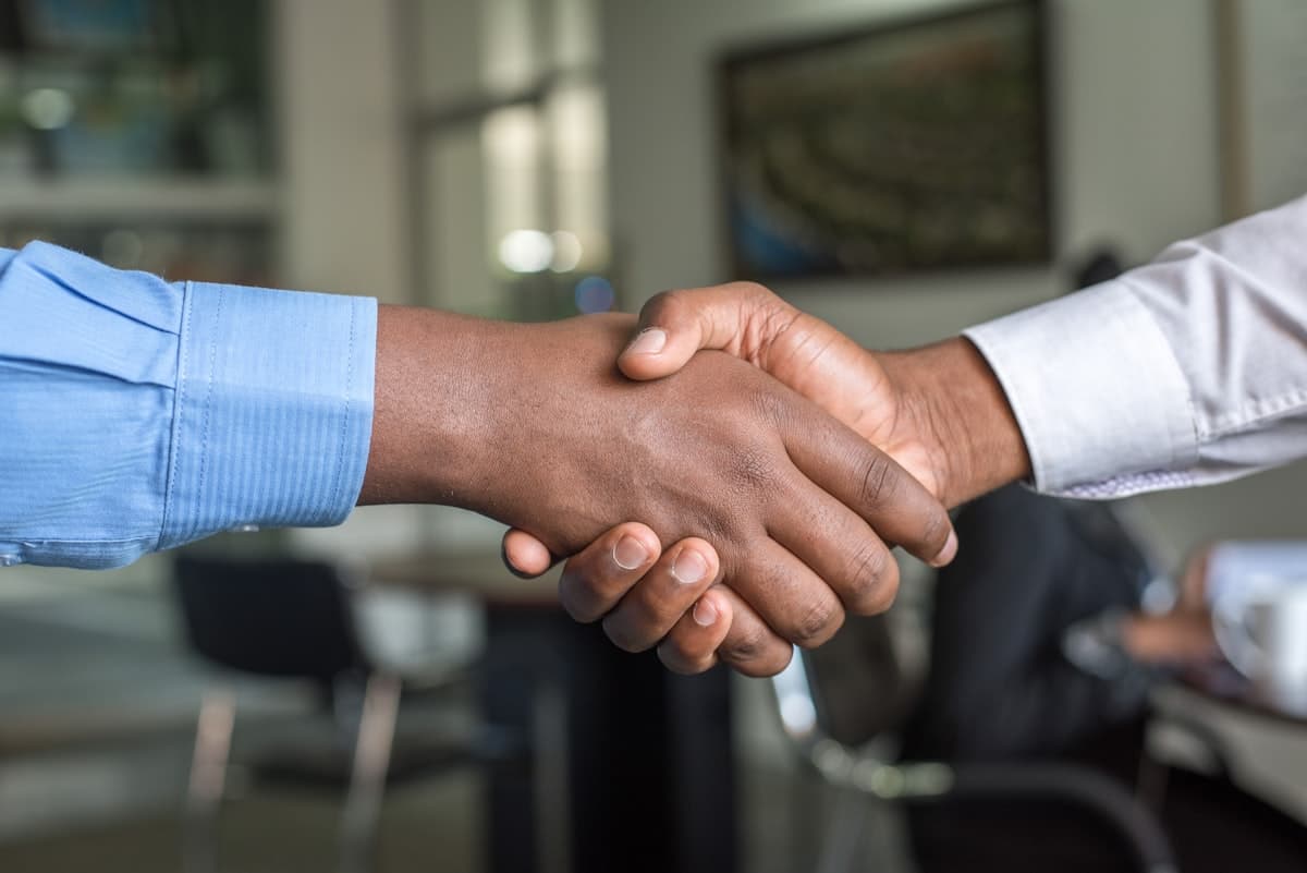 Two sales professionals closing a deal with a handshake after a live call